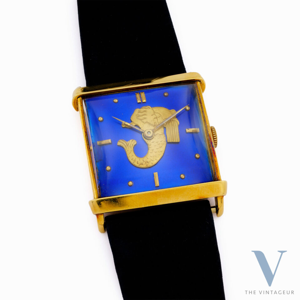 UNIVERSAL GENEVE "TRITON" REF. 10912, BLUE ENAMEL DIAL WITH EMBOSSED GOLD MINIATURE OF TRITON, SQUARE-SHAPED 18KT YELLOW GOLD CASE, HAND-WOUND UG 264 MOVEMENT, FROM THE 1940s