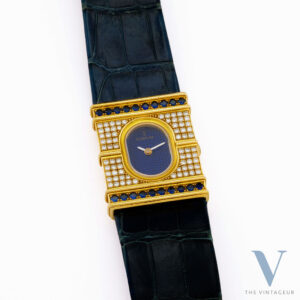 CORUM "ARC DE TRIOMPHE" REF. 24.374.65, BLUE GUILLOCHE DIAL, 18KT YELLOW GOLD CASE WITH DIAMONDS AND SAPPHIRES, ISA 125 QUARTZ MOVEMENT, FROM 1980